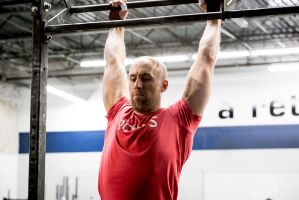 Man doing pull-ups in a CrossFit gym