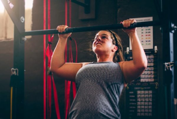 Woman powering through a pullup using strong mindset